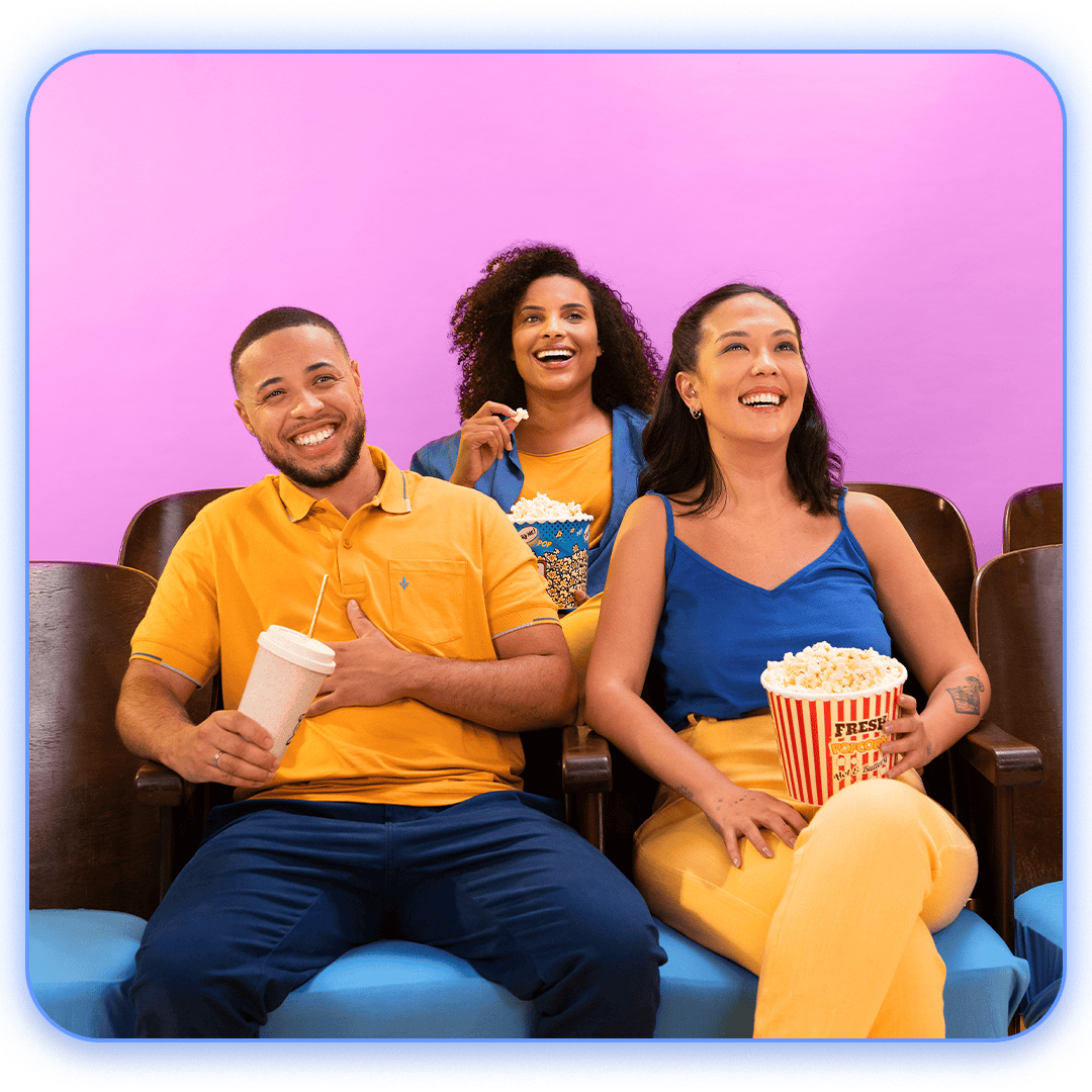 Pessoas feliz na sala de cinema comendo pipoca